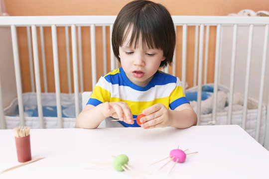 Cute little child made toothpick legs by playdough spiders