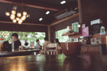 vintage tone of cup of coffee on table in Coffee shop blur backg