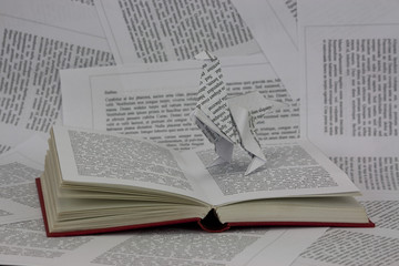 Origami dinosaur coming out of a book