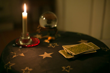 Tavolino da cartomante con tarocchi, candela e sfera di cristallo
