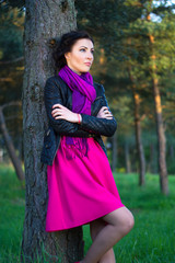 beautiful woman standing near the tree in summer forest