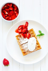 Pets (Belgian) waffles with strawberries and whipped cream.