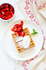 Pets (Belgian) waffles with strawberries and whipped cream.