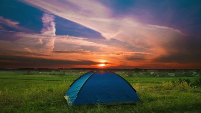 The camping tent by sunset (sunrise) background