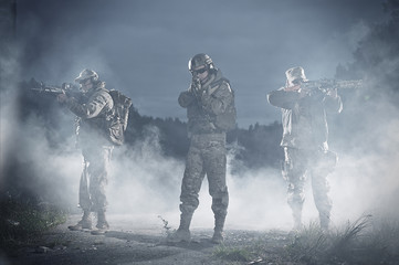 Men with rifle aiming in battlefield at night