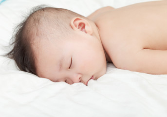 Closeup asian infant Sleeping on Soft Sheet,