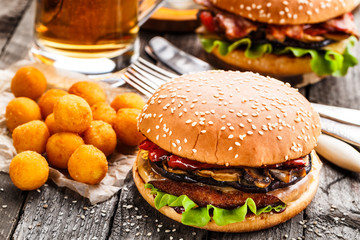 Delicious burger with fried potato balls and beer