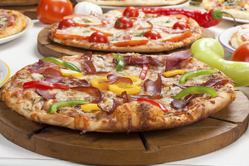 Pizza on wooden board served on the table.