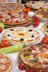 Several kinds of pizza served on the table.