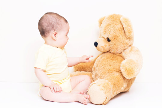 Beautiful baby playing with bear toy
