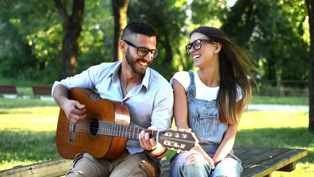 Giovane uomo suona la chitarra con la sua ragazza