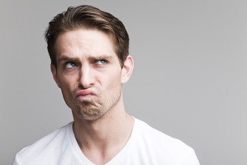 Fototapeta premium Doubting man in a white T-shirt