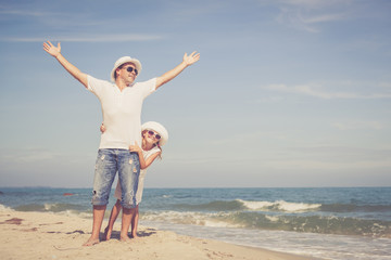 Father and daughter playing on the beach at the day time.