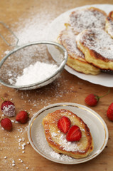 Sweet crumpets with strawberries and powdered sugar