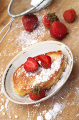 Sweet crumpets with strawberries and powdered sugar