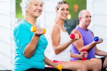 Senioren und Trainer mit Hanteln bei Fitness Sport