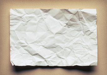 Crumpled  white paper card on beige background, place for text