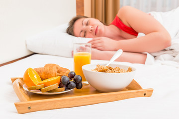 Obraz na płótnie Canvas sleeping woman and a tray with breakfast