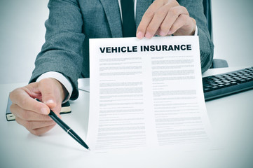 young man in suit showing a vehicle insurance policy