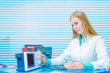 Woman with a tester and a printed circuit board
