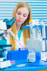 Laboratory assistant with long blonde hair fills microtubes for