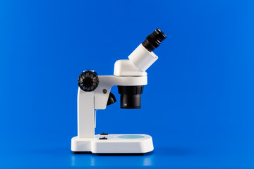 Incident binocular research microscope on blue background