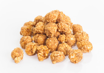 Almond and caramal popcorn on white background