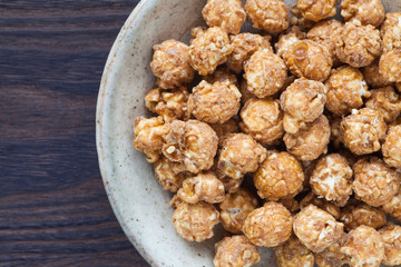 Almond and caramal popcorn on wood background