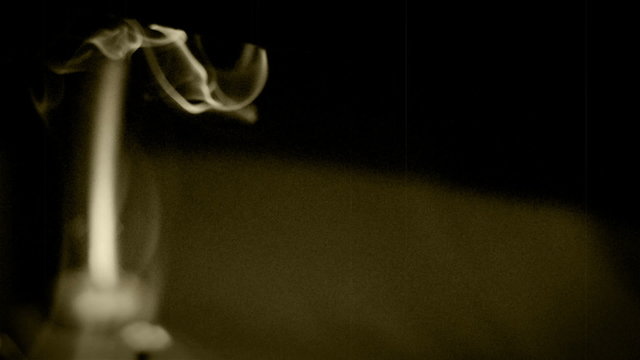 Cigarette/tobacco pipe smoke weaving in the desktop lamp light