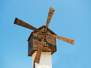 Old wooden windmill on blue sky background
