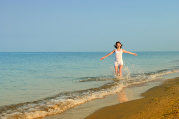 Fototapeta na wymiar The girl runs on a sandy beach