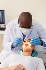 Obraz na płótnie Canvas young woman having teeth checked by dentist
