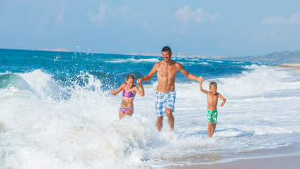 Father and children playing on the beach