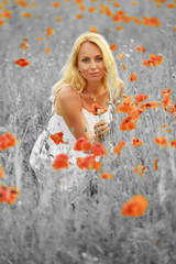 Pregnant happy woman in a flowering poppy field