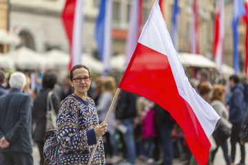 Woman on the street holding a flag of the Republic of Poland.