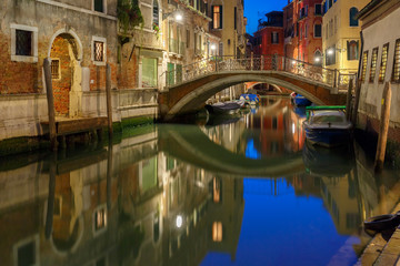 Fototapeta na wymiar Night lateral canal and bridge in Venice, Italy