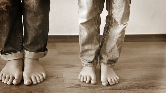 Black and white sepia footage: Mother and son fooling around stepping on each other's feet
