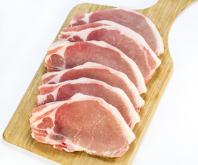 raw pork steaks on a cutting board