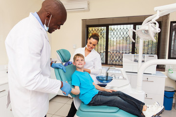 Obraz premium dentist congratulate little boy for a successful operation