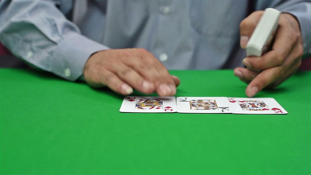 poker croupier distributes cards on green table