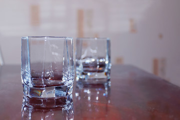 Closeup two cups of empty glass of whiskey on wooden table