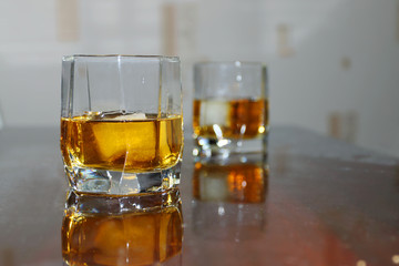 Closeup two glass cup with whiskey and ice on wooden table