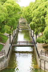 Fototapeta premium Summer sunny park with green trees, channel, beautiful bridges