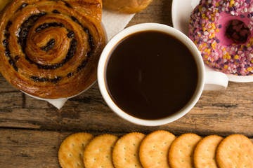 Cup of coffee on a wooden board and biscuits