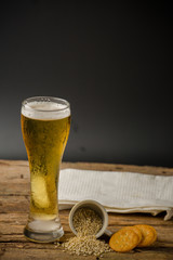 Glass of light beer on black background