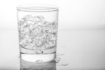 Glass of pure water with ice cubes.