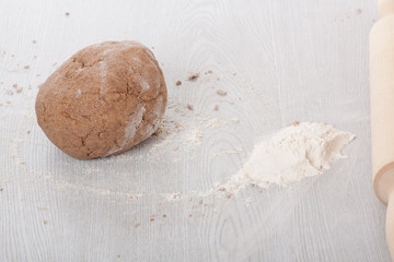 Dough with rolling pin on the table.