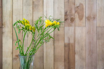still life of yellow freesia flowers on wooden background