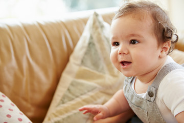 Happy Baby Boy Playing On Sofa At Home