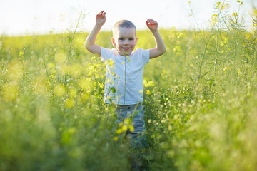 Naklejka na ściany i meble boy standing in rapeseed field